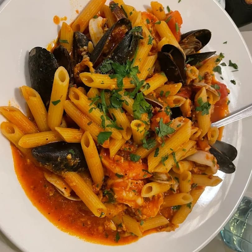 Penne pasta with mussels, clams, shrimp, and red sauce, garnished with parsley at Luberto's.